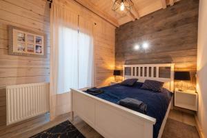 1 dormitorio con 1 cama en una habitación con paredes de madera en Perle (Ferienhaus) an der polnischen Ostsee en Perlino
