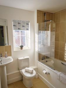 a white bathroom with a toilet and a sink at Beachcomber in Camber