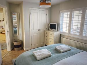a bedroom with a bed and a television on a dresser at Beachcomber in Camber