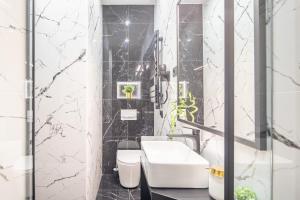 uma casa de banho em preto e branco com um lavatório e um WC em Extreme Central - Luxy Stay em Budapeste