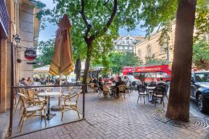 a sidewalk with tables and chairs and an umbrella at Extreme Central - Luxy Stay in Budapest