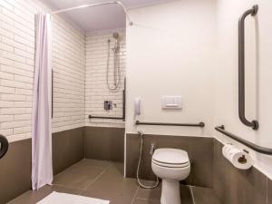 a bathroom with a toilet and a shower at ibis Ribeirao Preto Vila do Golf in Ribeirão Preto