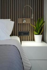 マスティハリにあるXeVa Studioのベッドルーム1室(ベッド1台、ナイトスタンドの植物付)