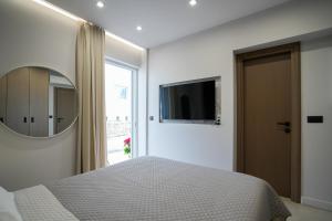 a bedroom with a bed and a mirror and a window at XeVa Studio in Mastichari