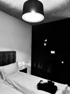 a black and white bedroom with a bed and a light at Design Flat Hidden Pearl Davos in Davos