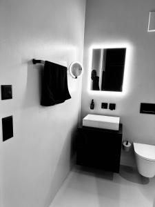 a white bathroom with a sink and a toilet at Design Flat Hidden Pearl Davos in Davos