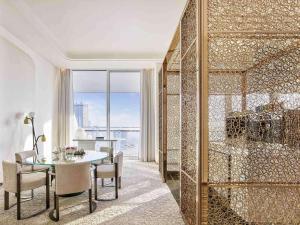 a dining room with a table and a glass wall at Fairmont Doha in Doha
