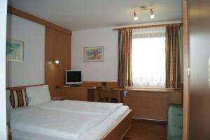 um quarto com uma cama, uma secretária e uma janela em Ferienhaus in Rauris mit Terrasse, Grill und Garten em Rauris