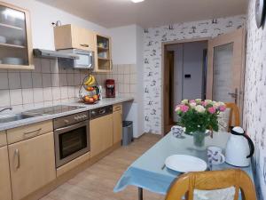 a kitchen with a table with a vase of flowers on it at Cozy holiday apartment in the Harz in Pöhlde