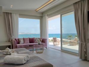 a living room with a purple couch and a view of the ocean at Hersonissos Beach Villa in Hersonissos