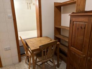 uma mesa de madeira e cadeiras num quarto com um closet em Stay in Islington/Arsenal em Londres