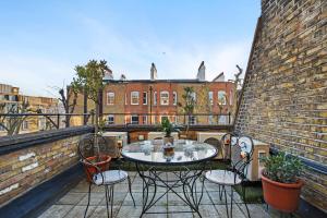 een patio met een tafel en stoelen op een balkon bij Twenty Nevern Square Hotel in Londen