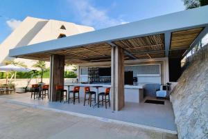 una cocina al aire libre con un bar con taburetes en Wyndham Grand Cancun All Inclusive Resort & Villas, en Cancún