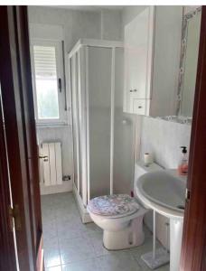 a white bathroom with a toilet and a sink at Chalet piscina privada Salamanca in Calvarrasa de Abajo