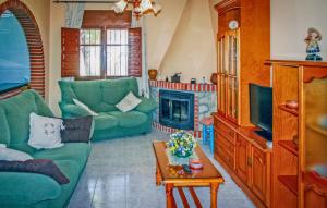 uma sala de estar com sofás verdes e uma lareira em Villa Almenara em Corumbela