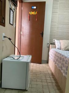 a room with a door with a bed and a pair of scissors at Pousada A Casa Portuguesa in Cabo de Santo Agostinho