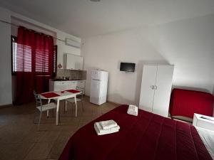 パレルモにあるAl Cortilettoのベッド、テーブル、キッチンが備わる客室です。