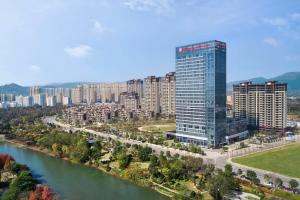 una ciudad con un edificio alto junto a un río en Hilton Garden Inn Ganzhou Longnan en Longnan