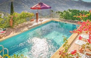 Corumbela的住宿－Villa Almenara，一个带遮阳伞和一些鲜花的游泳池