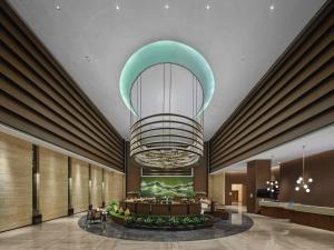 einen großen Kronleuchter in der Lobby eines Hotels in der Unterkunft Hilton Garden Inn Ganzhou Longnan in Longnan