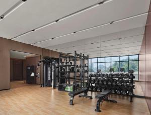 einen Fitnessraum mit vielen Trainingsgeräten in einem Zimmer in der Unterkunft Hilton Garden Inn Ganzhou Longnan in Longnan