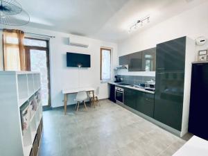 a kitchen with black and white cabinets and a table at Grand studio pour 2 Perpignan Bir Hakeim in Perpignan