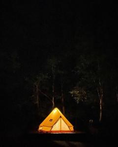 uma tenda amarela com uma luz no escuro em Oasis biei em Shibinai