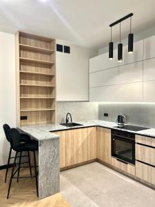 a kitchen with a counter and a sink and a stove at Apartament Zdrojowy Zakątek in Busko-Zdrój