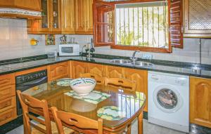 cocina con mesa, fregadero y lavavajillas en Villa Almenara, en Corumbela