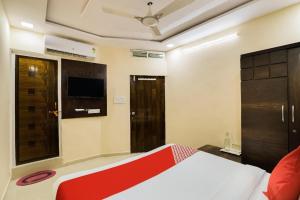 a bedroom with a bed and a tv and a window at Hotel Sunrise in Naroda