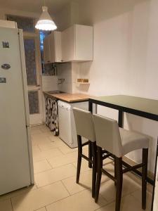 een keuken met een tafel, stoelen en een koelkast bij Comfortable and Friendly Apartment in Trieste