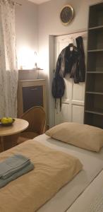 a bedroom with two beds and a table and a clock at Апартаменти біля рондо - Mieszkanie przy Rondzie in Przemyśl