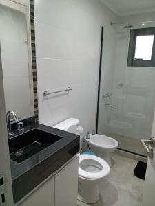 a bathroom with a toilet and a sink and a shower at Complejo Ermindo I in Rafaela