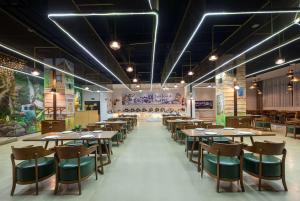 - un restaurant avec des tables et des chaises dans une salle dans l'établissement Days Inn by Wyndham Chongqing Tongliang, à Tongliang