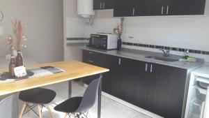 a kitchen with a table and chairs and a sink at Complejo Ermindo I in Rafaela