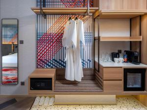 een kleedkamer met witte kleren aan de muur bij Mercure Bangkok Surawong in Bangkok