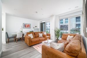 een woonkamer met een bank, stoelen en een tafel bij Madika Homes - Cosy 2 Bed 2 Bath in Colindale London in Colindale