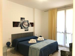 1 dormitorio con 1 cama y reloj en la pared en Baia Blu RTA Residence en Lerici