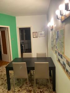 una sala da pranzo con tavolo e sedie neri di Comfortable and Friendly Apartment a Trieste