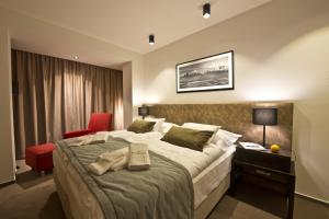 a bedroom with a large bed and a red chair at Hotel Lesna – Adult Friendly in Stará Lesná