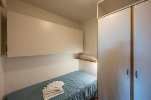 a small room with a bed and a cabinet at Vayamundo Oostende - Apartments in Ostend