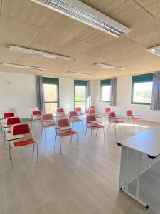 an empty room with chairs and tables in a classroom at Casa Santa Elena in Santa Cristina d'Aro