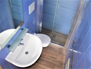 ein Badezimmer mit einem weißen Waschbecken und einem WC in der Unterkunft monolocali residence petraroli by salentolimit in Porto Cesareo