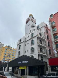 a white building with a clock tower on top of it at Victoria Hotel in Mokpo