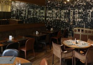 a restaurant with tables and chairs and a wall with photographs at Saifi Suites in Beirut