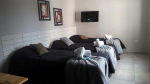 a room with two beds and a flat screen tv at Complejo Ermindo I in Rafaela