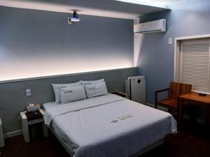 a bedroom with a large bed with white sheets at Victoria Hotel in Mokpo