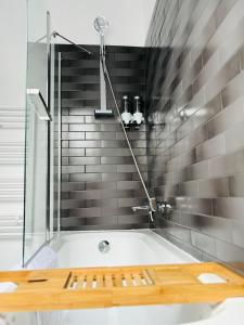 a bathroom with a bath tub with a shower at Popa Apartment in Cluj-Napoca