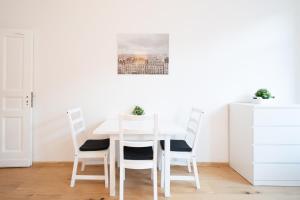 a white dining room with a white table and chairs at Apt Volt - Modern, neu, komplett ausgestattet, 4 Einzelbetten, zentral mit Waschmaschine Spülmaschine TV Herd Backofen Mikrowelle in Fürstenwalde