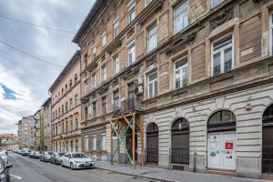 un bâtiment avec des voitures garées sur le côté d'une rue dans l'établissement Central and Cute with 3 rooms and AC, à Budapest